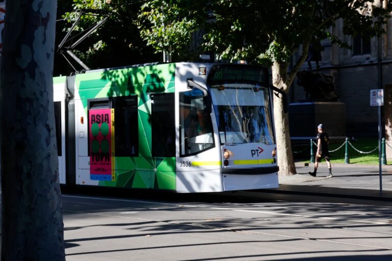 Um Bonde Com Detalhes Verdes Passa Por Uma Rua EizmDWND110