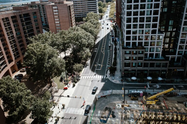 Vista Aerea De Uma Rua Da Cidade Com Predios E Arvores qRvFYUNyf4I