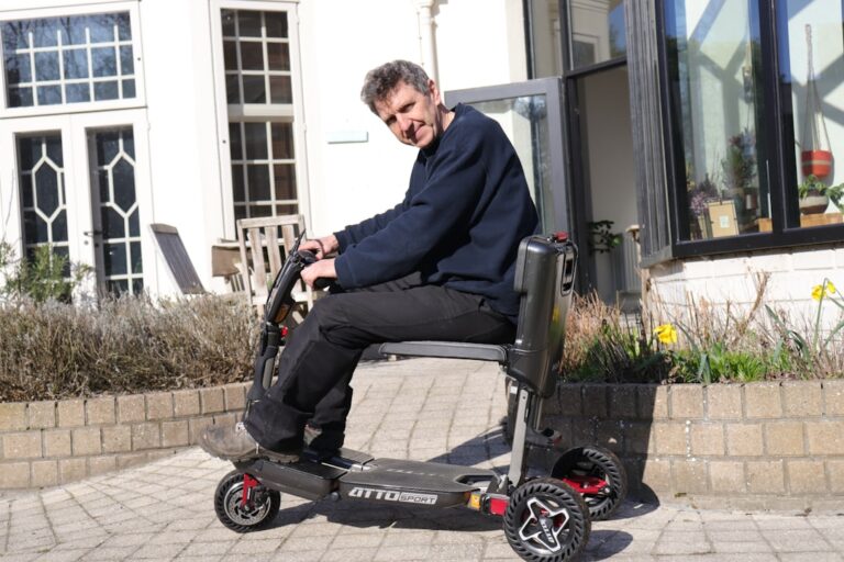 Homem Andando Em Uma Scooter De Mobilidade Do Lado De Fora De Um Predio Ej1xxi0o IY