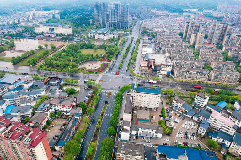 Vibrant aerial view of urban landscape with greenery and modern architecture in China.