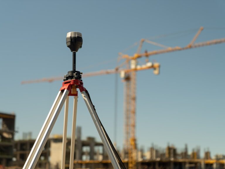 Um Tripe Com Uma Camera Acoplada a Ele Em Frente a Um Canteiro De Obras OO4laKg2HS0